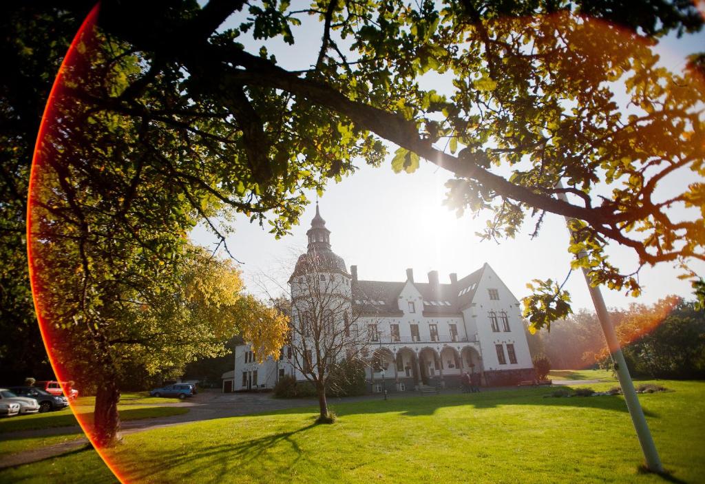 ティダホルムにあるHellidens Slott och Vandrarhemの木の立つ広い白い建物