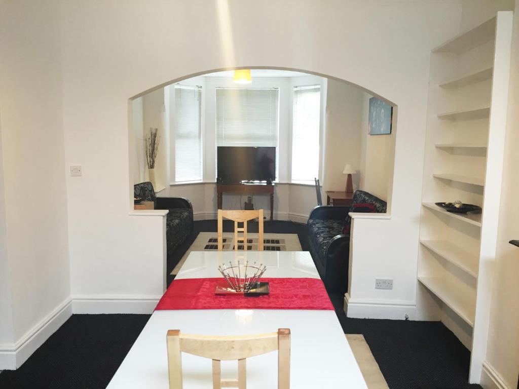 a living room with a table with a red rug at South Central Contractors Townhouse in Manchester