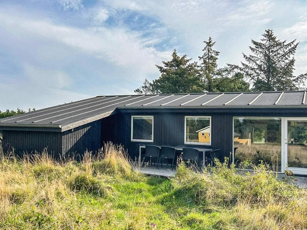 una casa negra con techo solar en una colina en Cozy Retreat in Sonderho - By Traum Ferienwohnungen, en Sønderho