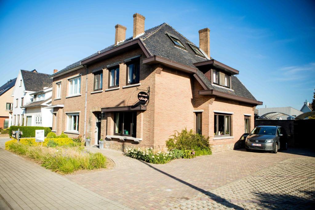uma casa com um carro estacionado em frente em B&B 't Solveldje em Bilzen