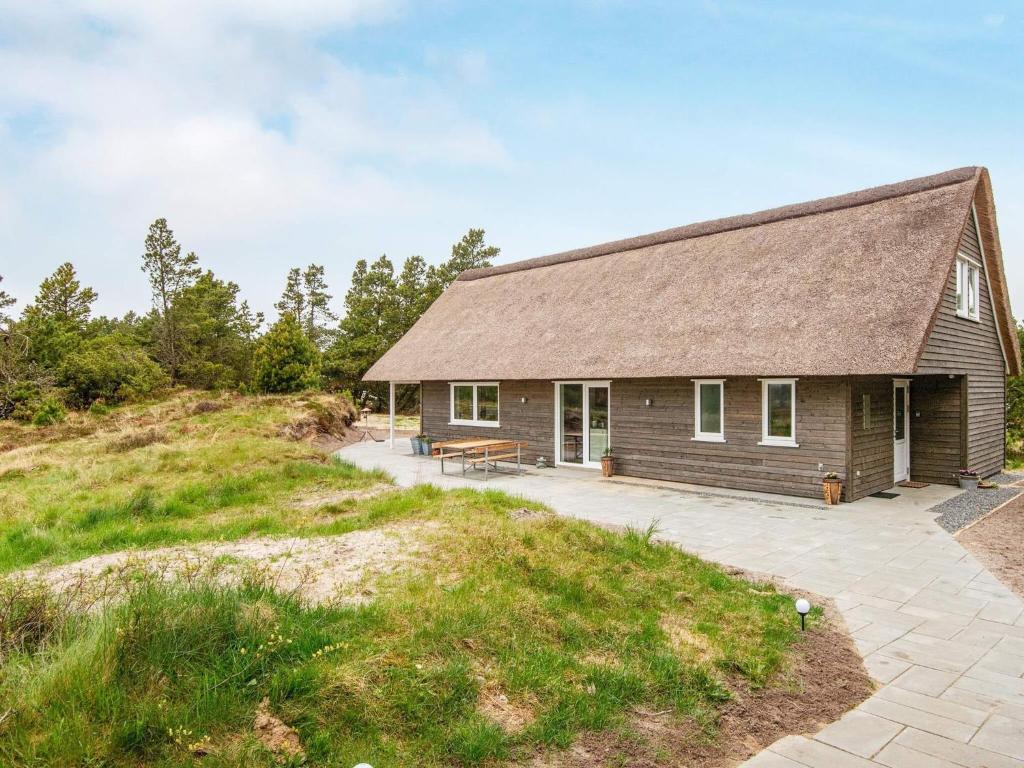 a house with a roof on top of a hill at 6 person holiday home in Rømø-By Traum in Toftum