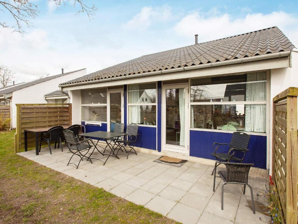 a house with a patio with chairs and a table at 4 person holiday home in Væggerløse in Marielyst