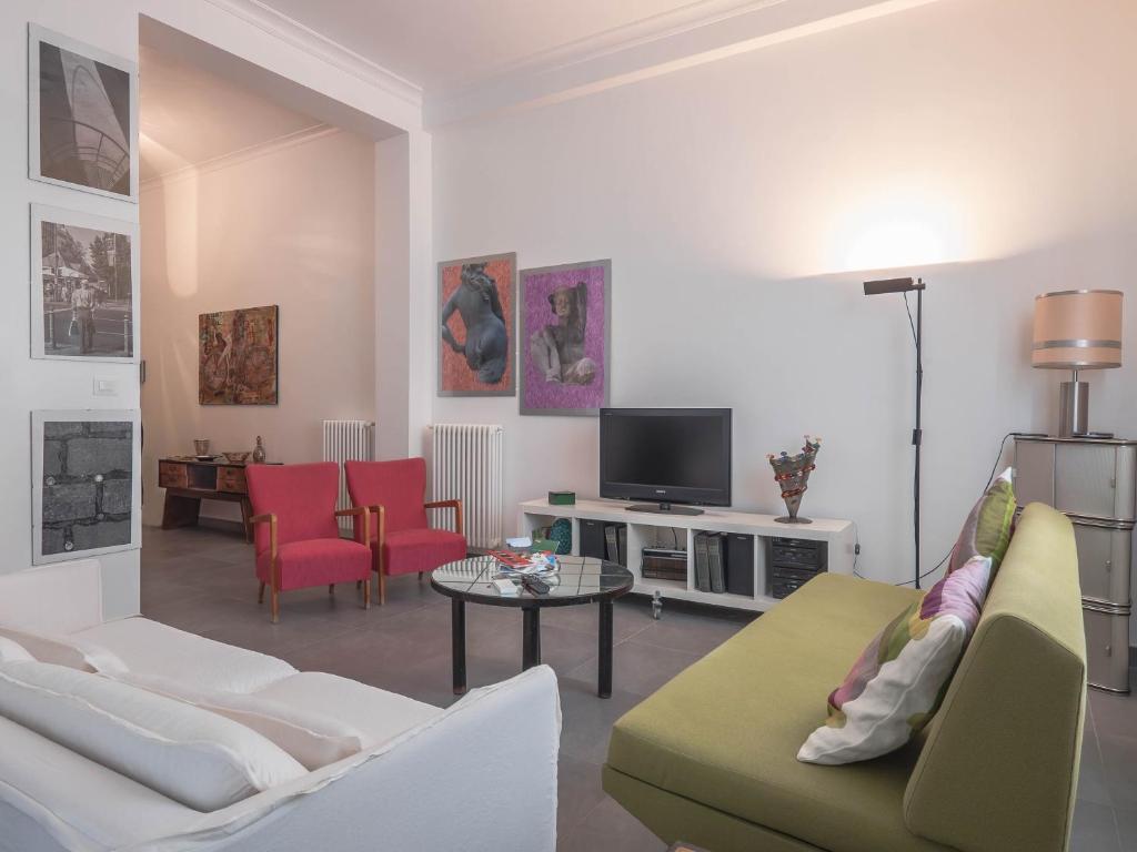 - un salon avec un canapé et une télévision dans l'établissement Casa Rosa, à Palerme