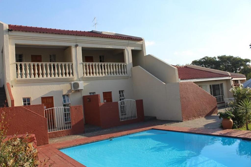 a house with a swimming pool in front of it at Flamboyant Guest Lodge in Johannesburg