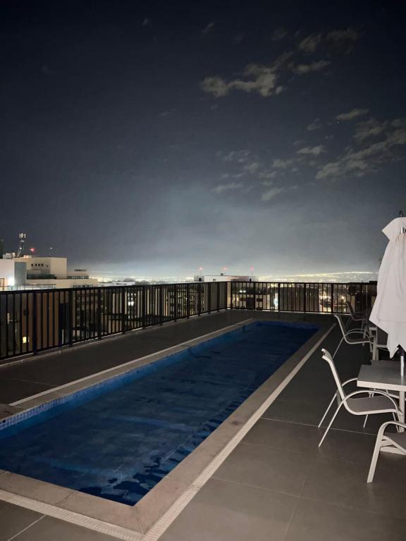 una piscina en la azotea de un edificio por la noche en Nobile Suites, Flats Rocha, en Brasilia