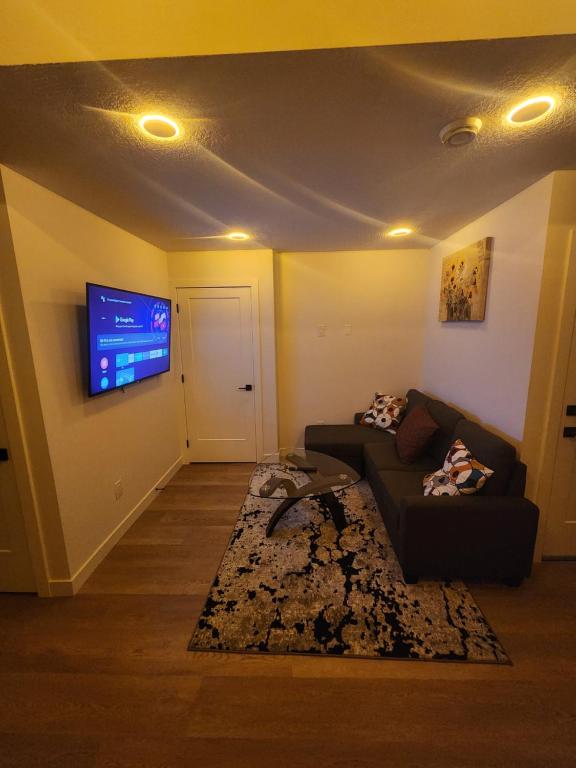 un salon avec un canapé et une télévision à écran plat dans l'établissement Home in Calgary, à Calgary