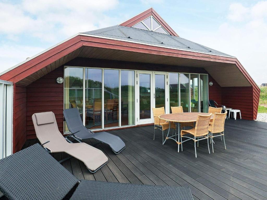 a patio with a table and chairs on a deck at 8 person holiday home in Løkken-By Traum in Løkken