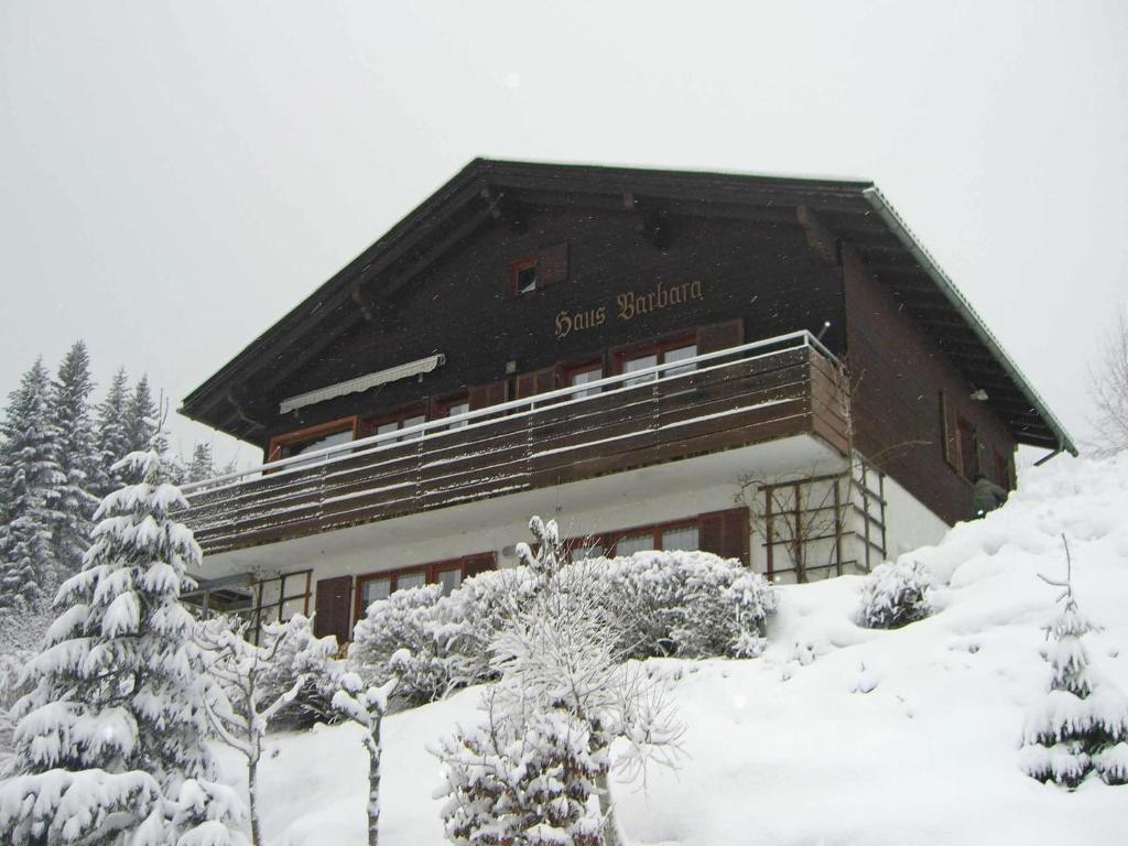 un edificio cubierto de nieve con árboles delante en Chalet in Vorarlberg near Ski Slopes, en Egg