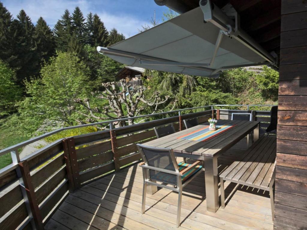 a wooden deck with a picnic table and an umbrella at Chalet in Vorarlberg in Egg