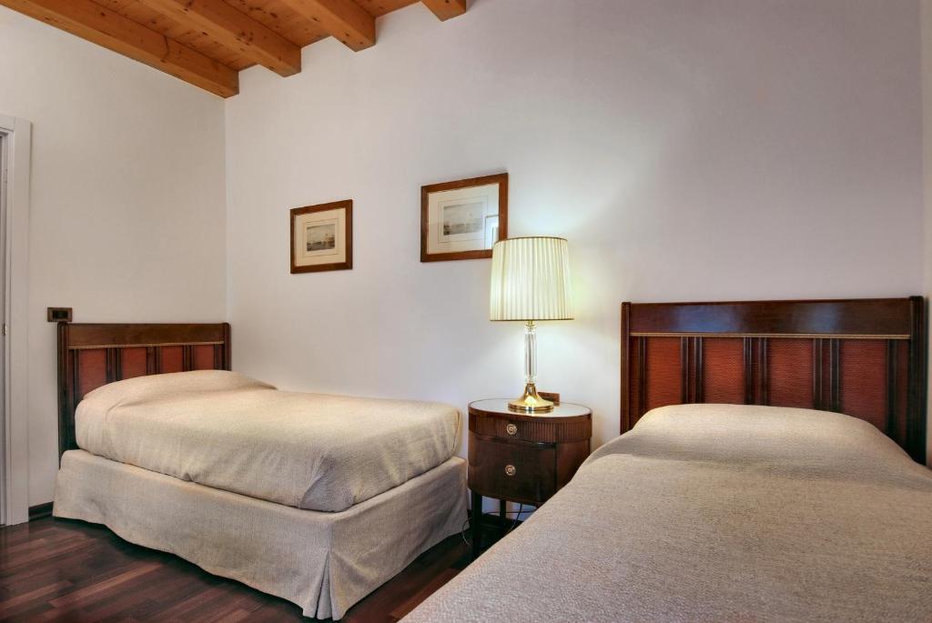 a bedroom with two beds and a lamp on a table at Villa Dacri in Venice-Lido