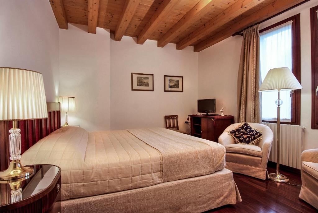 a bedroom with a bed and a desk and a chair at Villa Dacri in Venice-Lido