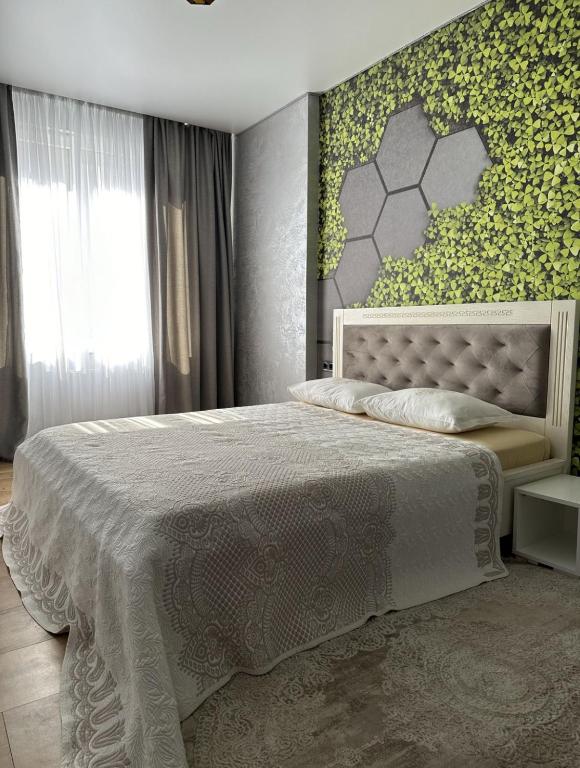 a bedroom with a large bed with a green wall at Квартира,Еврейская,1 in Bilhorod-Dnistrovskyi