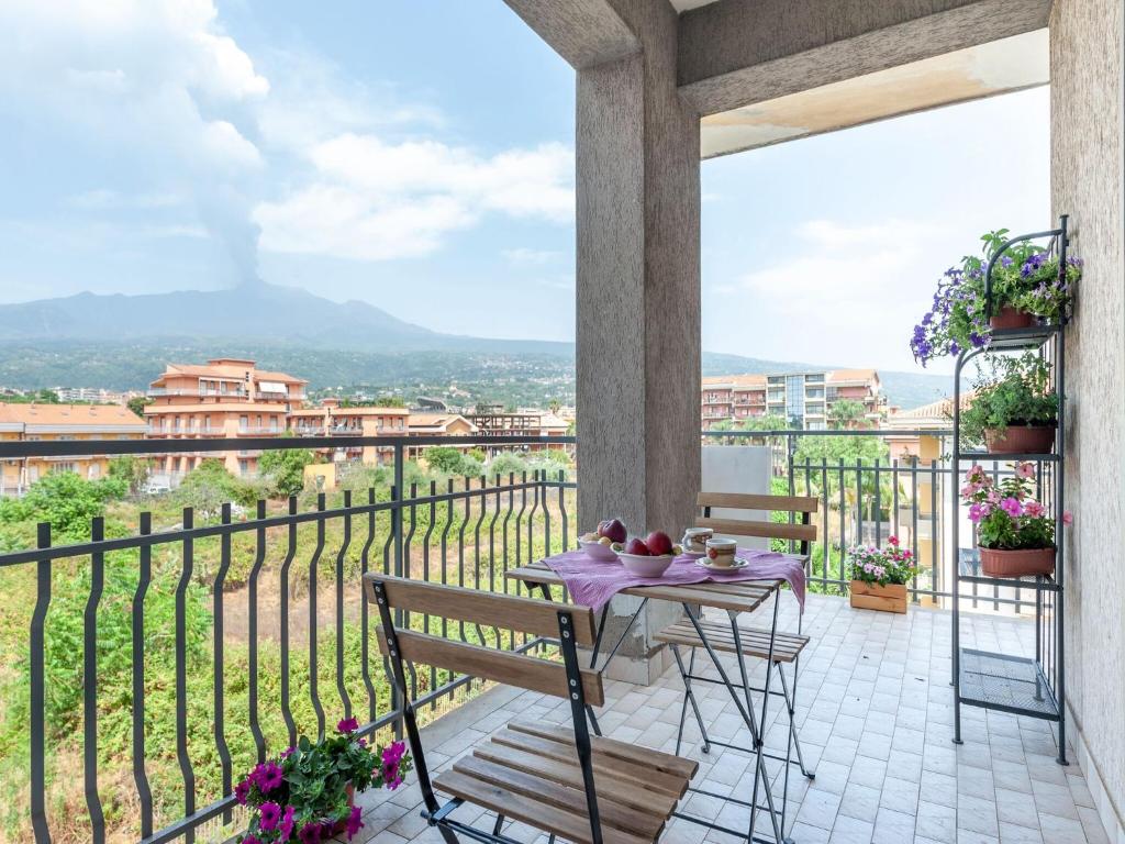 a table and chairs on a balcony with a view at Etna & Sea View Apartment in Giarre
