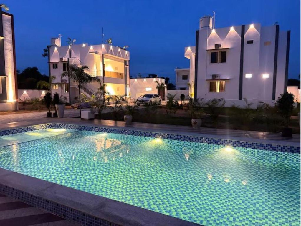 a swimming pool in front of a building at night at Le Park Luxury Resort - TIE Hotels & Resorts in Puducherry