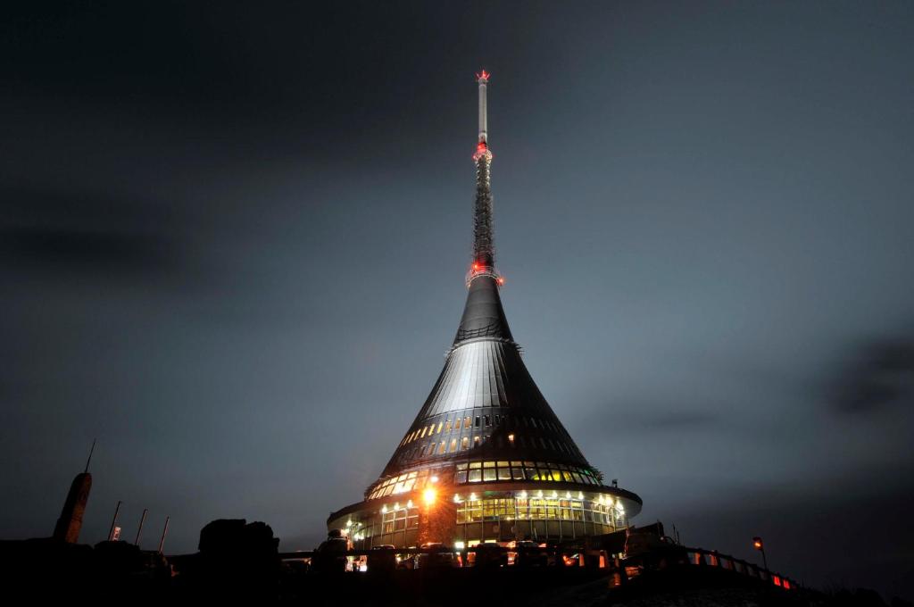 a building with a spire at night at Hotel Ještěd in Liberec