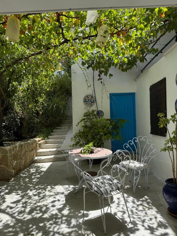 patio con sedie, tavolo e porta blu di Despertar ad Antequera