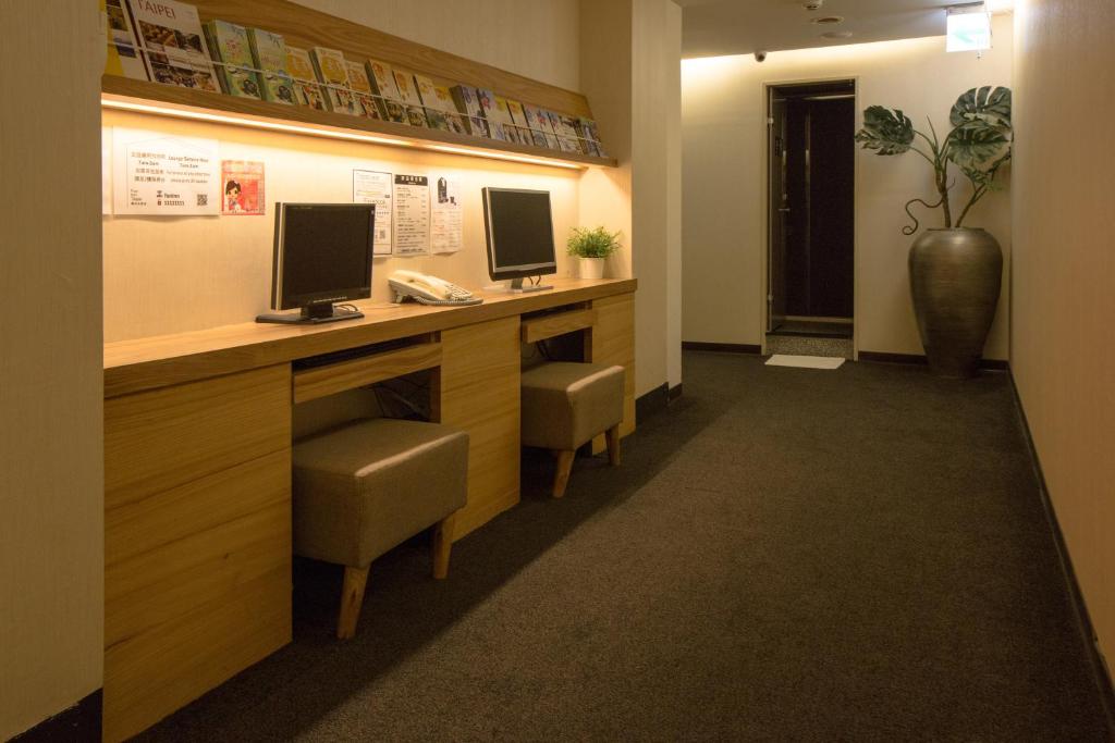 a waiting room with a desk with two monitors on it at Fun Inn Taipei Hostel in Taipei