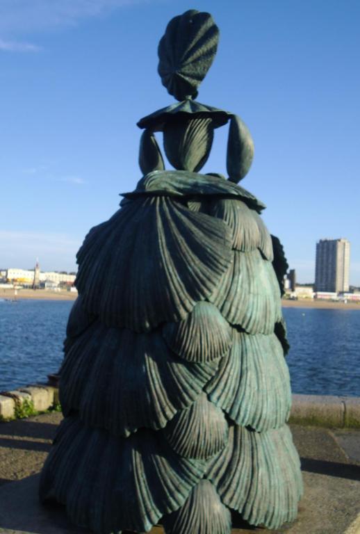 a statue of a woman sitting on top of a pile of trash at Andorinho Sea View Apartment in Margate
