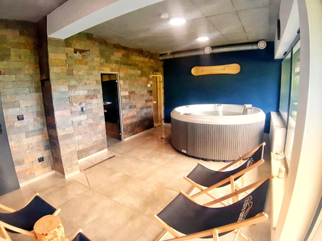 a large room with a tub and chairs in it at Apartament w górach ze SPA in Szczyrk