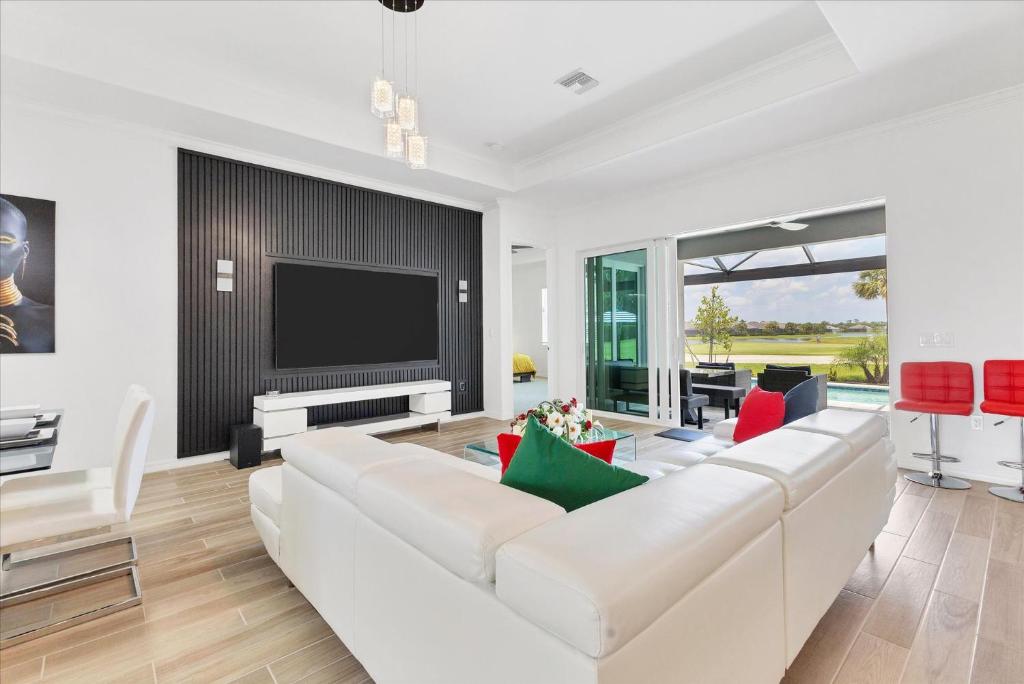 Una sala de estar con muebles blancos y un televisor de pantalla plana. en GRH14692 - Charlotte Harbor Area - 3 Bed 3 Baths Villa, en Tropical Gulf Acres
