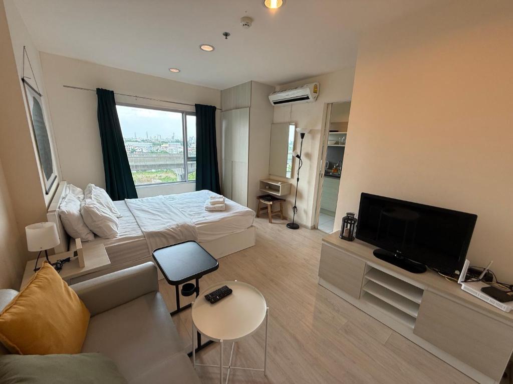 ein Schlafzimmer mit einem Bett, einem Fernseher und einer Couch in der Unterkunft Cozy7 Living in Bangkok60 m to MRTnear chatuchank in Ban Bang Khwang