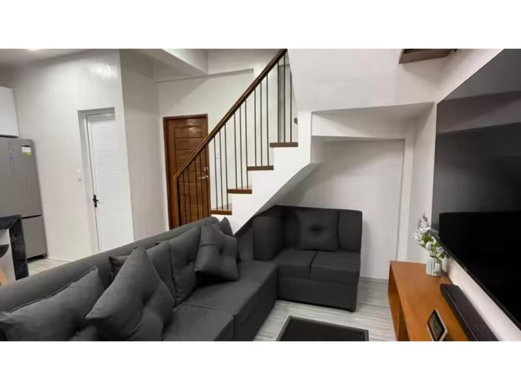 a living room with a couch and a staircase at The Escape - Malolos in Mujon