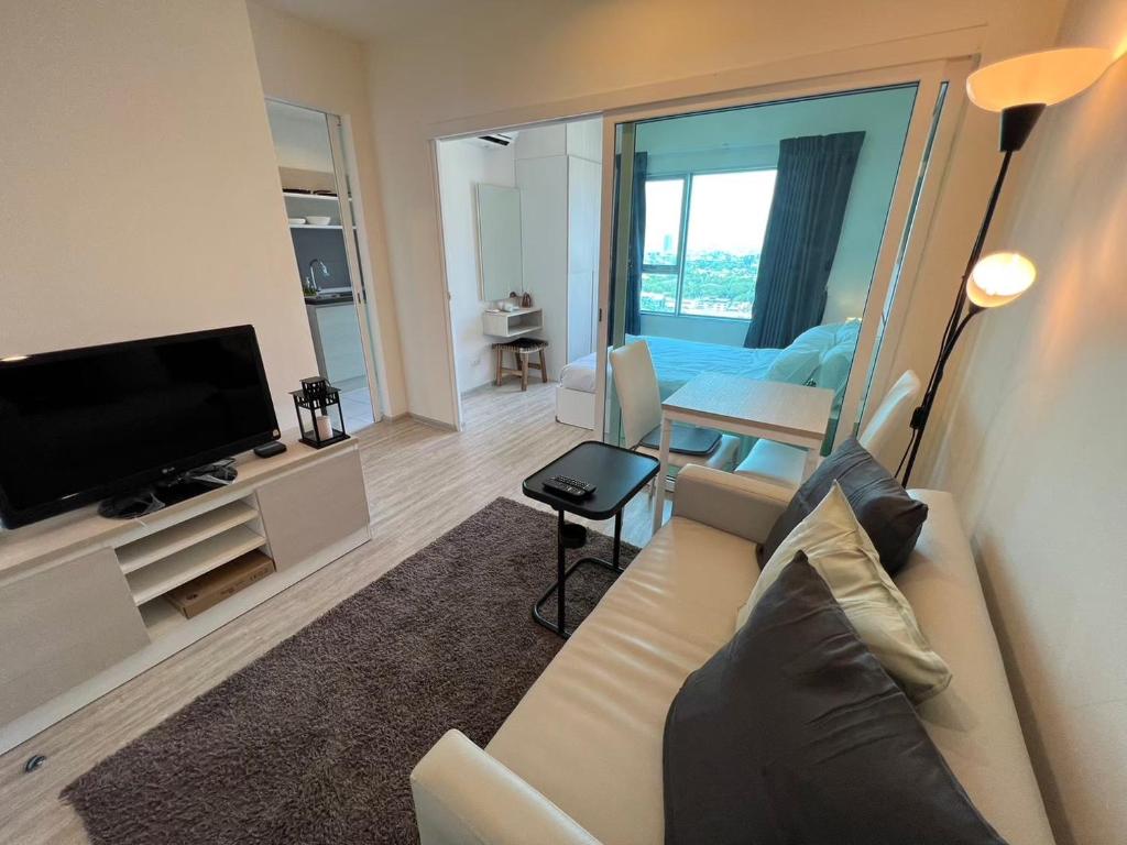 ein Wohnzimmer mit Couch und Flachbildfernseher in der Unterkunft Cozy8Living in Bangkok 60mto MRT in Ban Bang Khwang