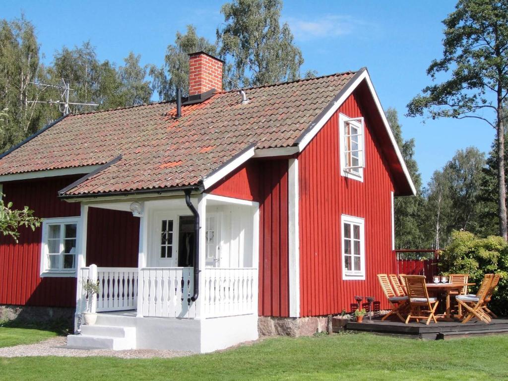 a red and white house with a table at 6 person holiday home in GLANSHAMMAR-By Traum in Glanshammar