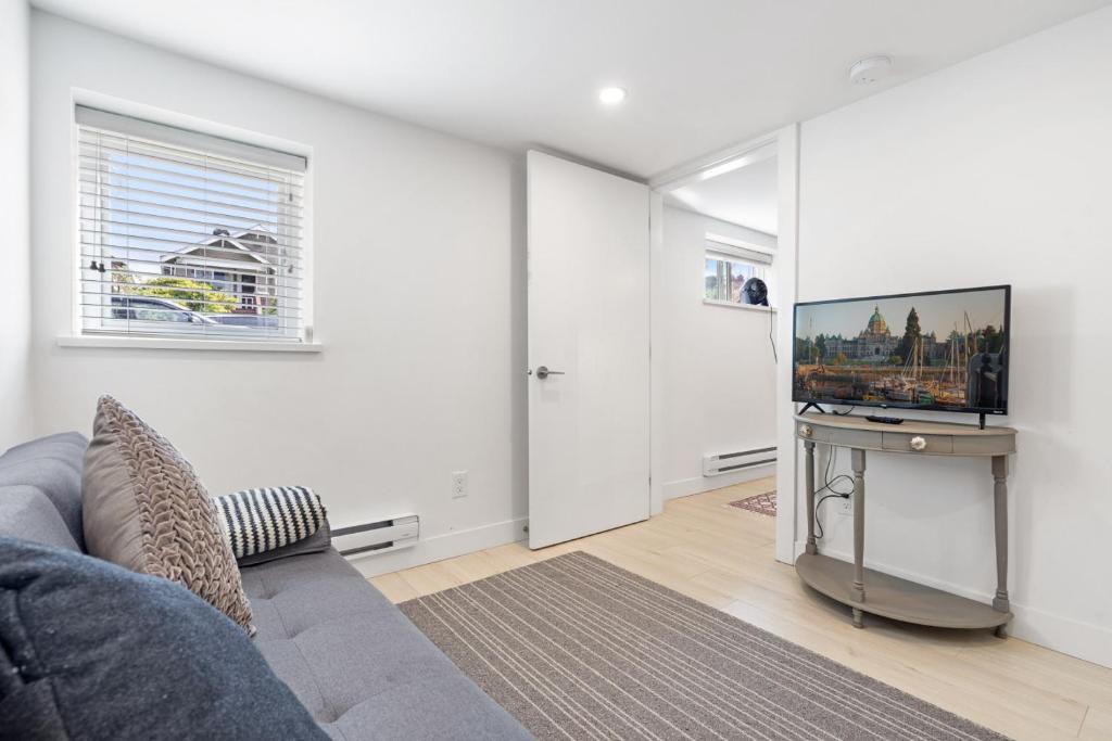 a living room with a couch and a flat screen tv at Callister BNB in Vancouver
