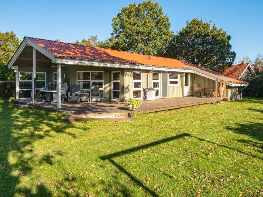 a small house with a deck and a yard at 8 person holiday home in Glesborg-By Traum in Glesborg