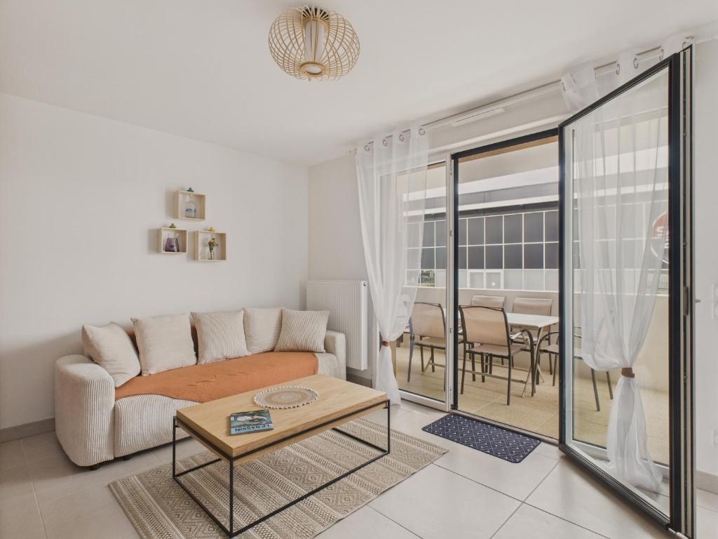 a living room with a couch and a table at Plein centre - Appart pour 6 avec balcon in La Teste-de-Buch