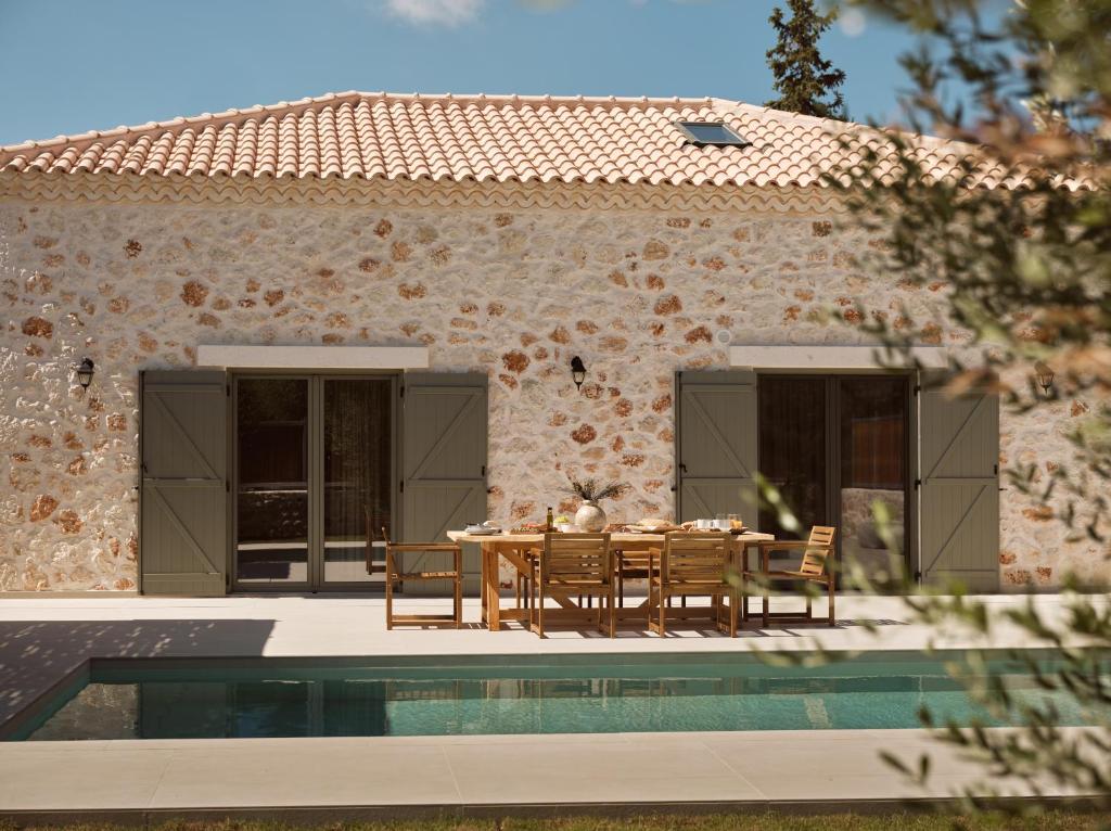 a patio with a table and chairs next to a house at Conte Maris IV in Tragaki