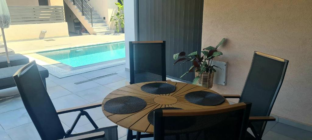 una sala da pranzo con tavolo e piscina di Theros a Nikiana