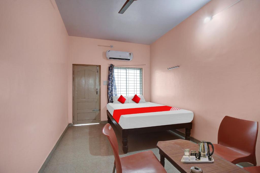 a small room with a bed and a table at Hotel O New Mayuri Lodge in Bāgepalli