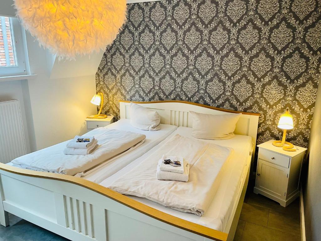 a bedroom with a bed with two towels on it at Stadthotel-Garni Smutje in Norden