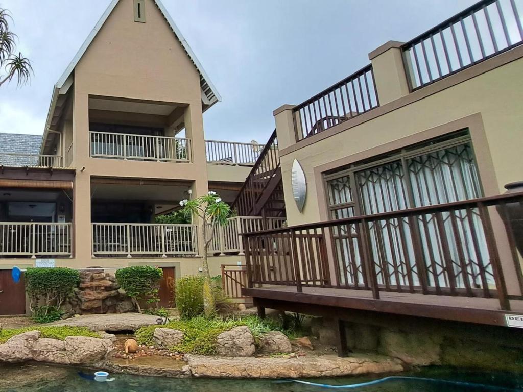 a house with a balcony and a pond in front of it at 29 on St James Guest Lodge in Durban
