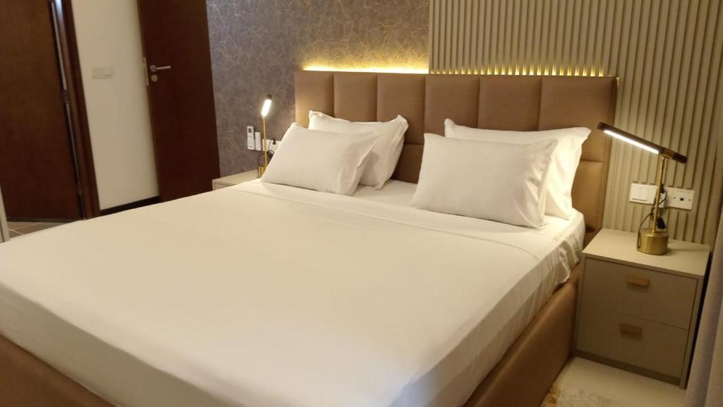 a bedroom with a large bed with white sheets and pillows at Colombo, Trizen Luxury Apartments, Sri Lanka in Colombo