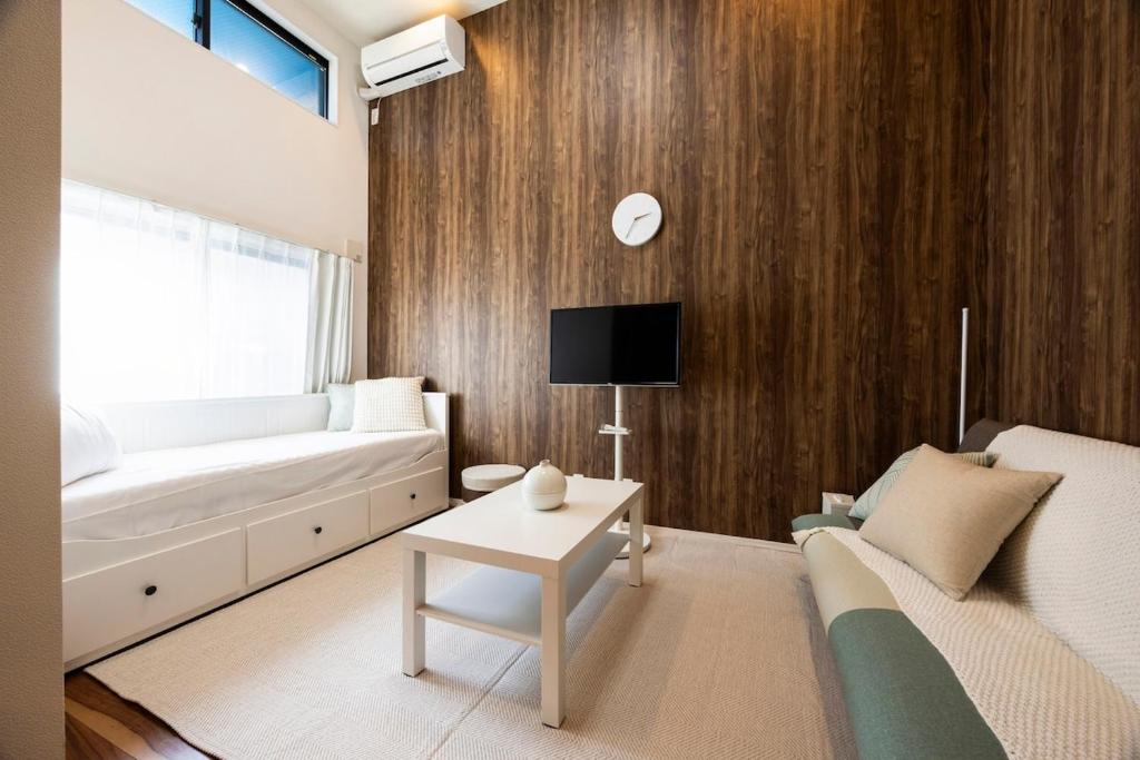 een woonkamer met een bank en een tv bij Residence Noa 101 in Fukuoka