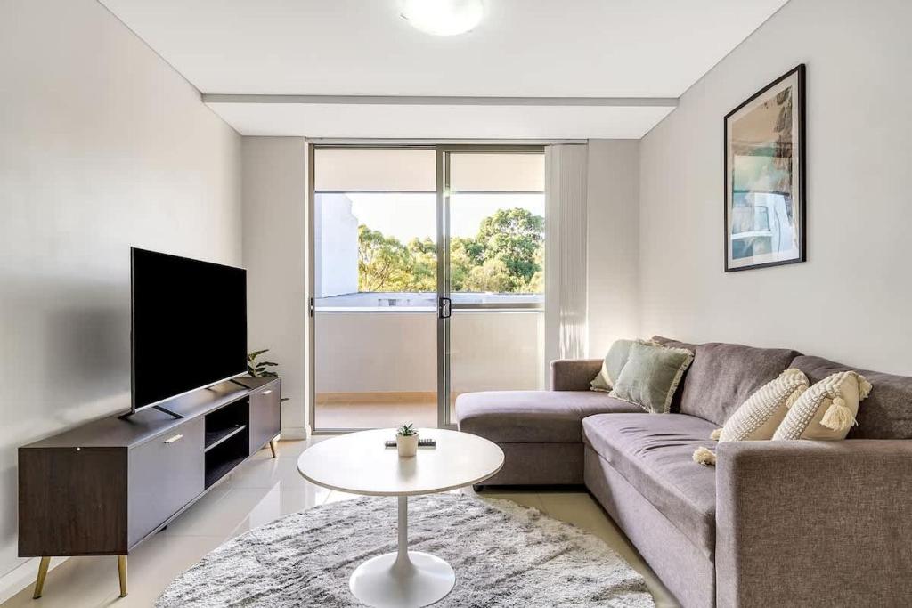 a living room with a couch and a tv at 11B Abnb-Style Charming 12 Mins Walk Train STA Free parking2BR in Bankstown