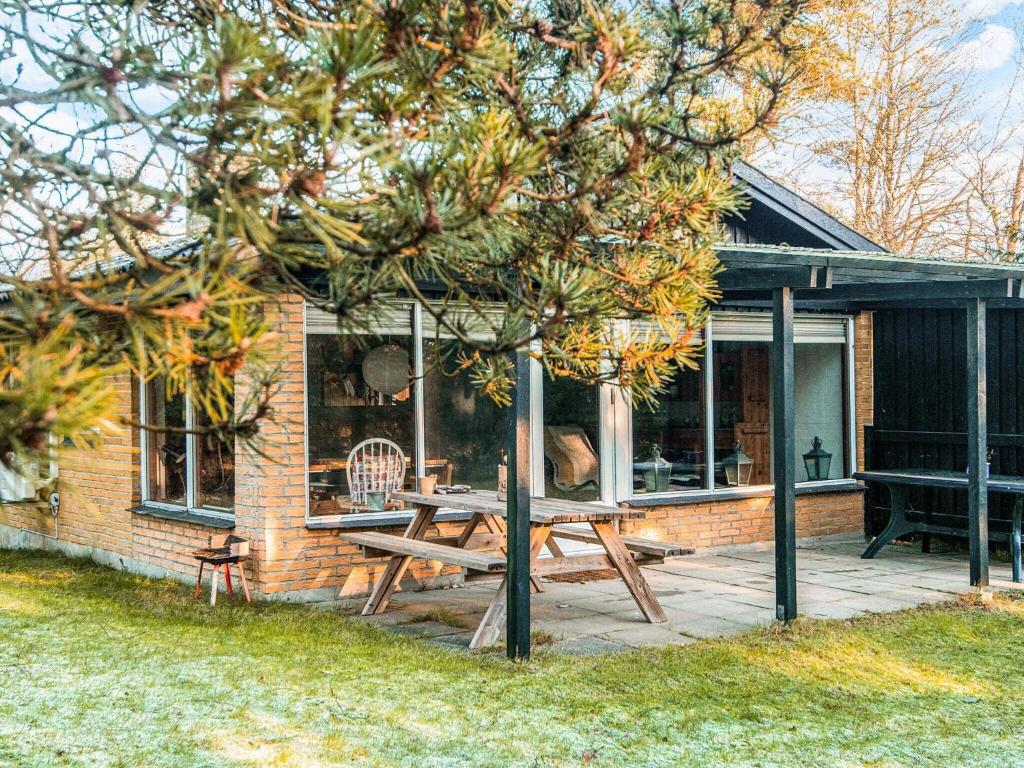 a picnic table on a patio in front of a house at 2 person holiday home in Tarm in Fjerbæk