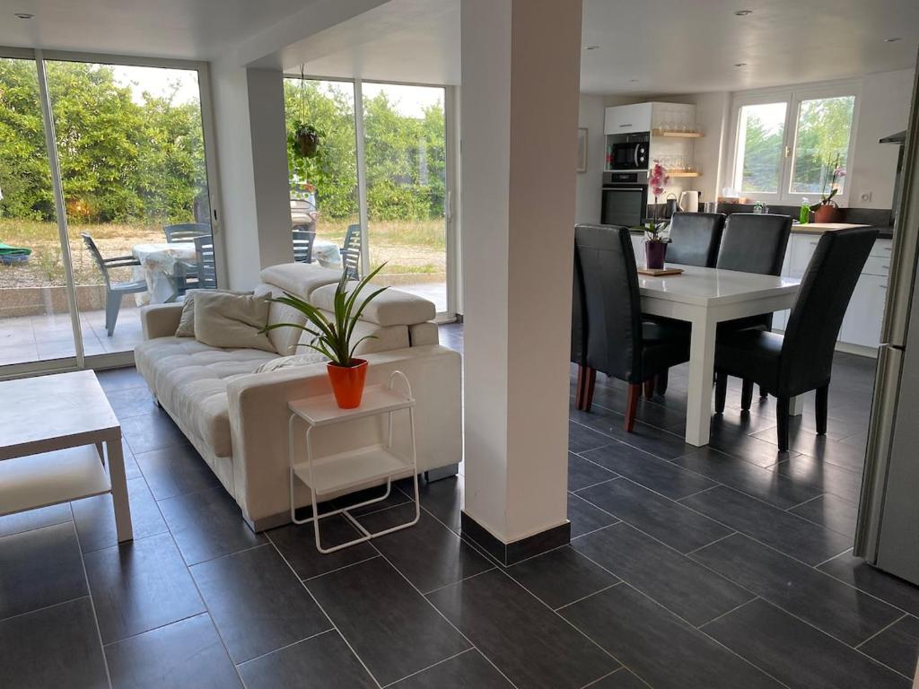 a living room with a couch and a table and a dining room at Maison avec jardin, à deux pas de Paris in Deuil-la-Barre