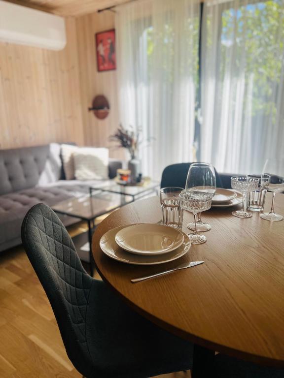 a wooden table with plates and wine glasses on it at Lake House in Telšiai