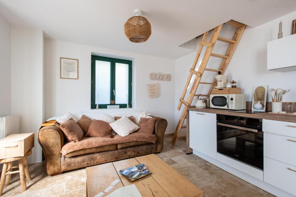 un soggiorno con divano e cucina di Le Domaine des Amours - Jacuzzi Privé a Saint-Josse