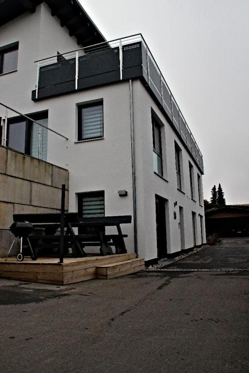 a white building with a picnic table in front of it at Bayerwaldapartment in Viechtach