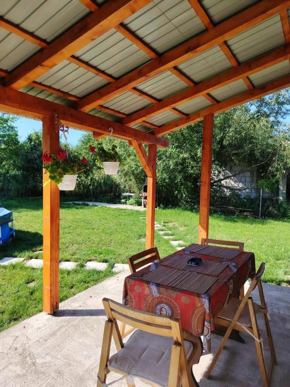 a picnic table and chairs under a wooden pergola at Cabana Briana in Valea Drăganului
