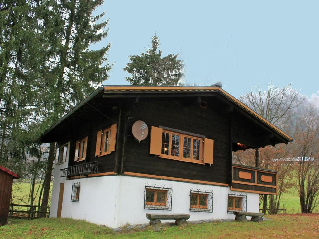 a small house with a black roof and windows at Chalet in Sibratsgfäll near Ski Slopes in Sibratsgfäll