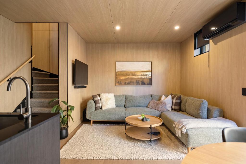 un salon avec un canapé et une table dans l'établissement Raua Luxury Queenstown Villa, à Queenstown