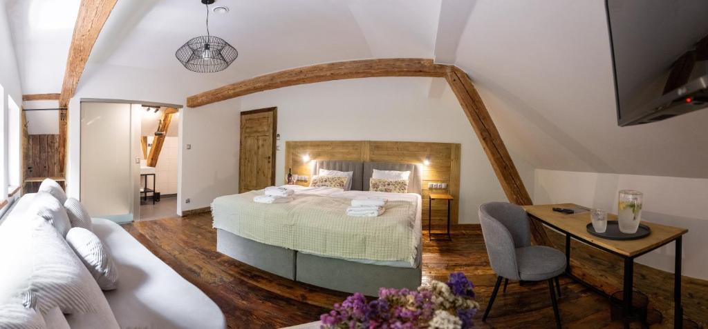 1 dormitorio con 1 cama grande, mesa y silla en Gospoda Dębowiec520, en Bielsko-Biala