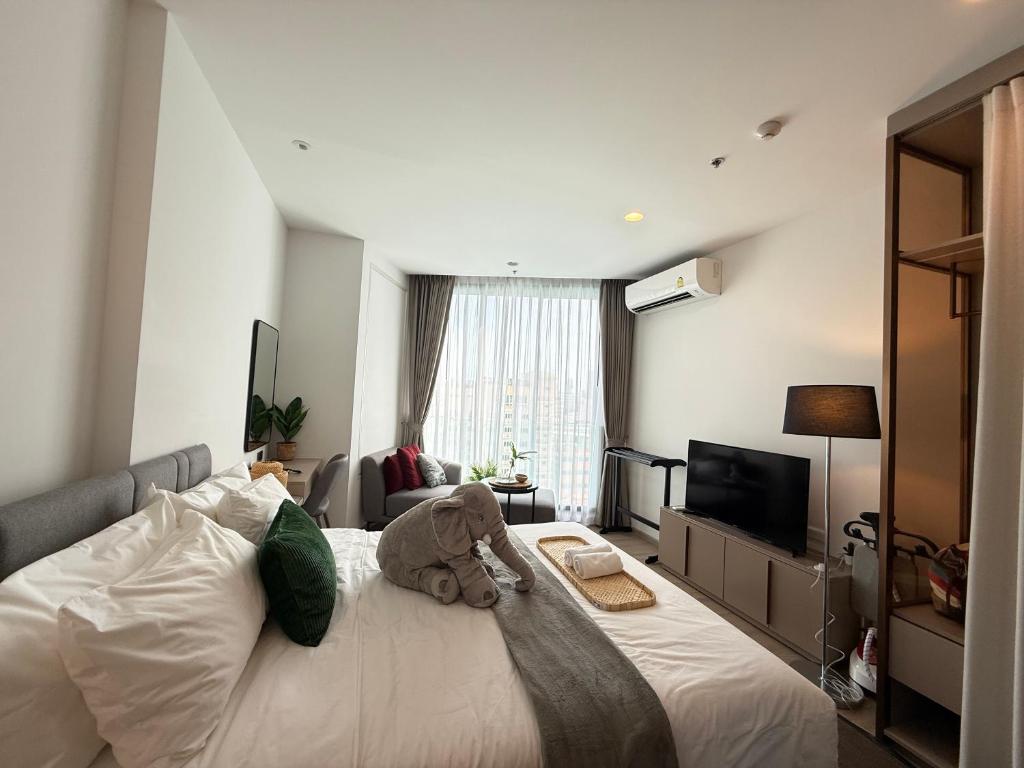 a teddy bear sitting on a bed in a bedroom at Edge central Pattaya by kansiree in Pattaya