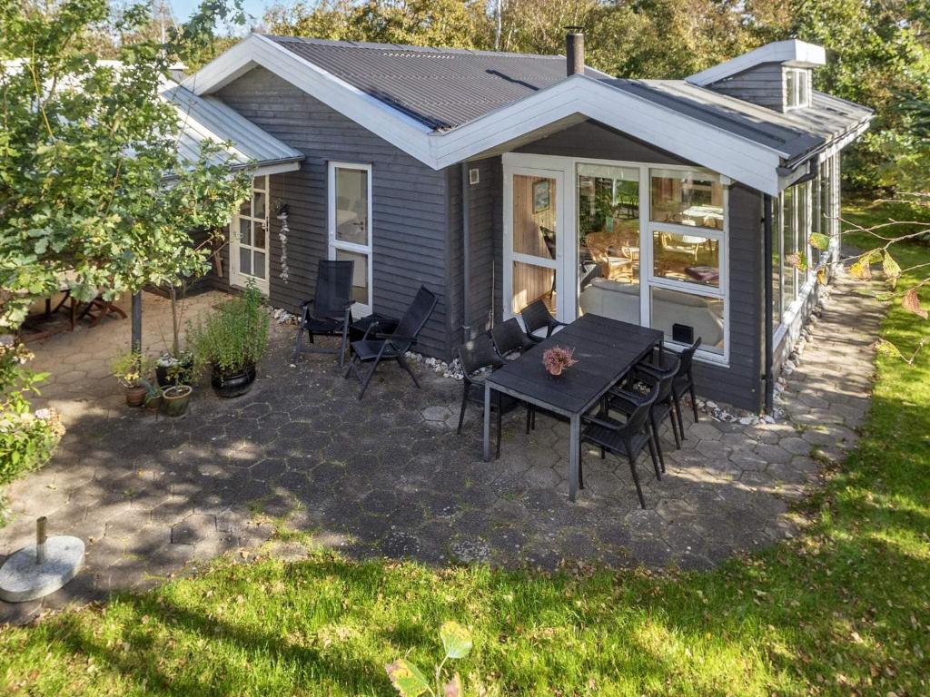 a small blue house with a table and chairs at Tranquil Waterside Retreat-By Traum in Thyholm